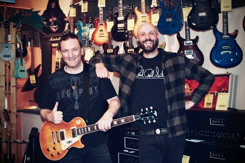 Foto von Herb und Kris im Laden mit Gitarren im Hintergrund